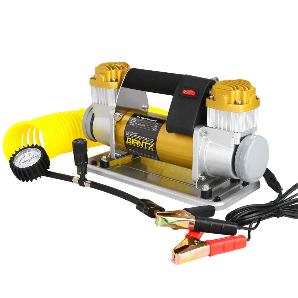 A Giantz Air Compressor 12V 4x4 Tyre 200L/MIN Deflator Inflator Car Truck Portable features a metallic body with gold-colored accents and is equipped with a handle for easy carrying. It includes a coiled yellow hose, a pressure gauge, cables with red and black clamps for power connection, and a precise deflation valve.