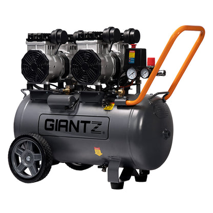 The large, black Giantz 50L Air Compressor 3.0HP Oil-Free Quiet Electric Portable Air Inflator boasts an efficient oilless lubrication system and a spacious 50L compressor. It features two black motors on top, pressure gauges, and a control panel on one side. With two large wheels, a small front support, and an orange handle, it ensures easy maneuverability.