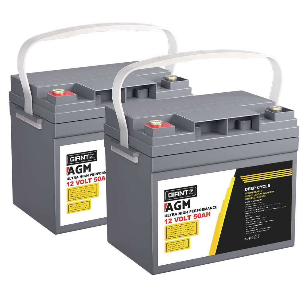 Two grey AGM deep cycle batteries, each featuring white handles and labels reading "Giantz AGM Deep Cycle Battery 12V 50Ah x2 Box Portable Solar Caravan Camping," with red and gold terminals on top. These portable power units are positioned side by side, slightly angled to the right.