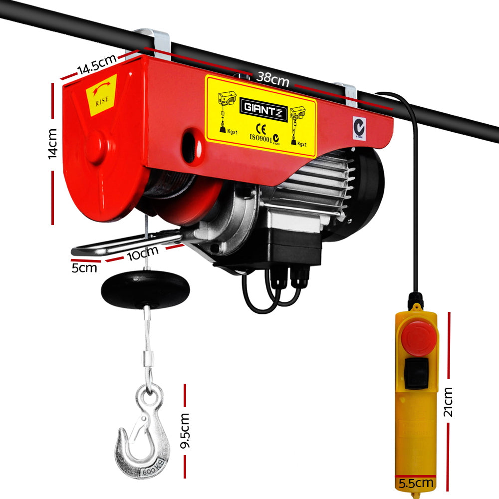 A red and silver electric hoist with a steel cable and hook, featuring a hand-held yellow remote control. The Giantz Electric Hoist Winch 300/600KG Cable 18M Rope Tool Remote Chain Lifting, boasting a 600KG capacity and 1200W power, is mounted on a metal beam. It is designed for lifting heavy objects effortlessly.