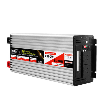 The image shows a silver-colored 2500W power inverter labeled "Giantz Power Inverter 12V to 240V 2500W/5000W Pure Sine Wave Camping Car Boat" with a LED display and specifications indicating 2500W max continuous power and 5000W peak power. The pure sine wave inverter includes switches, sockets, indicator lights, and supports wireless remote control on its black front panel.