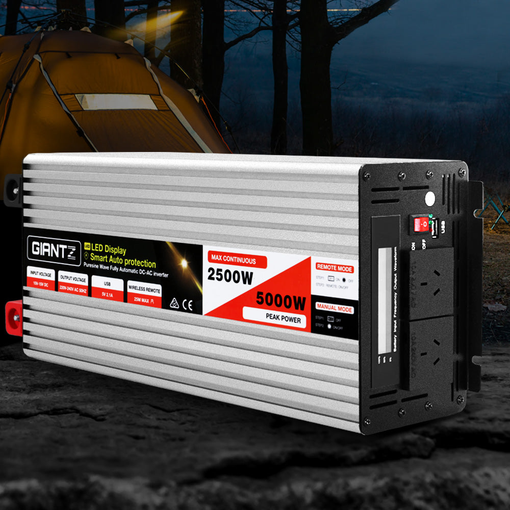 The image shows a silver-colored 2500W power inverter labeled "Giantz Power Inverter 12V to 240V 2500W/5000W Pure Sine Wave Camping Car Boat" with a LED display and specifications indicating 2500W max continuous power and 5000W peak power. The pure sine wave inverter includes switches, sockets, indicator lights, and supports wireless remote control on its black front panel.