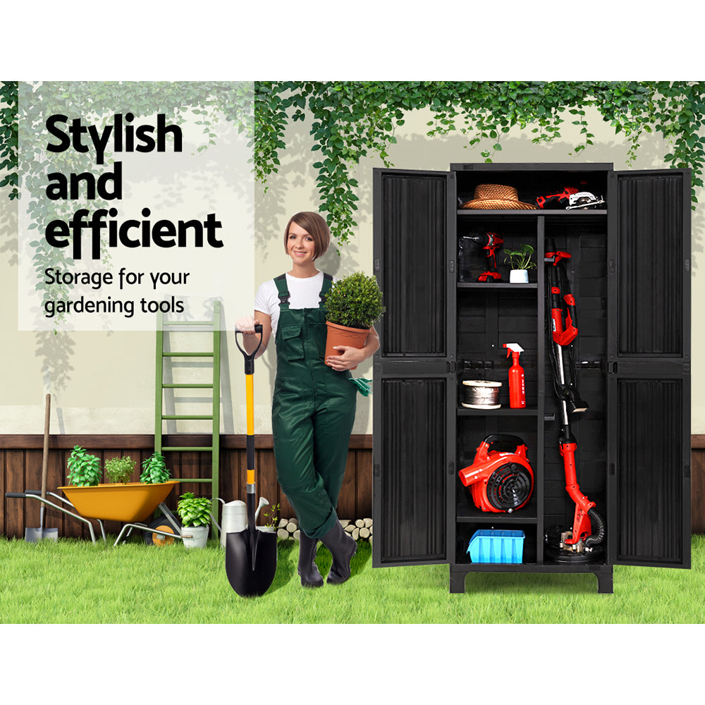 A black Gardeon 173cm Outdoor Storage Cabinet Box Lockable Cupboard Sheds Garage Adjustable reveals organized, adjustable shelves. Inside are red power tools, a small plant, a hat, cleaning supplies, a hose reel, and a box. The weather-resistant cabinet houses items like a handheld vacuum and hedge trimmer among other assorted gear.