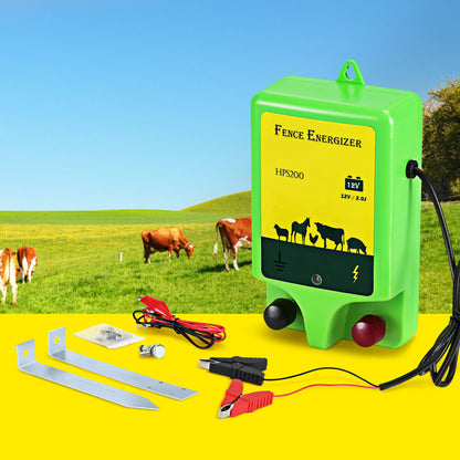 A green and yellow battery-powered Electric Fence Energiser labeled "Giantz 18km Electric Fence Energiser 1.56J" features images of livestock on it. The device includes a power indicator and two knobs. Attached are black and red cables with alligator clips for connection, ensuring reliable livestock protection.