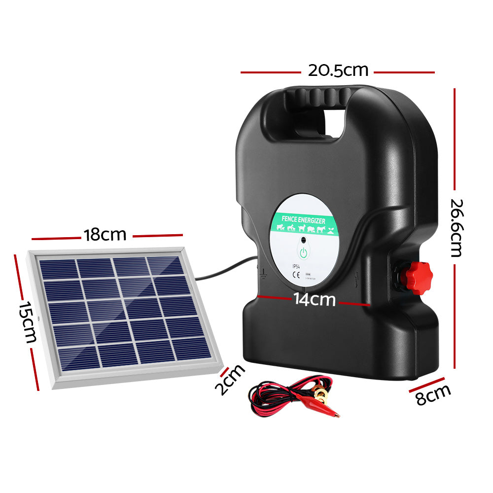 A black, portable Giantz Fence Energiser 20KM Solar Powered 1.2J Electric with a handle on top ensures livestock protection. It's connected to a small solar panel by a cable, employing two red alligator clips attached to black and red wires in front of the waterproof energizer.