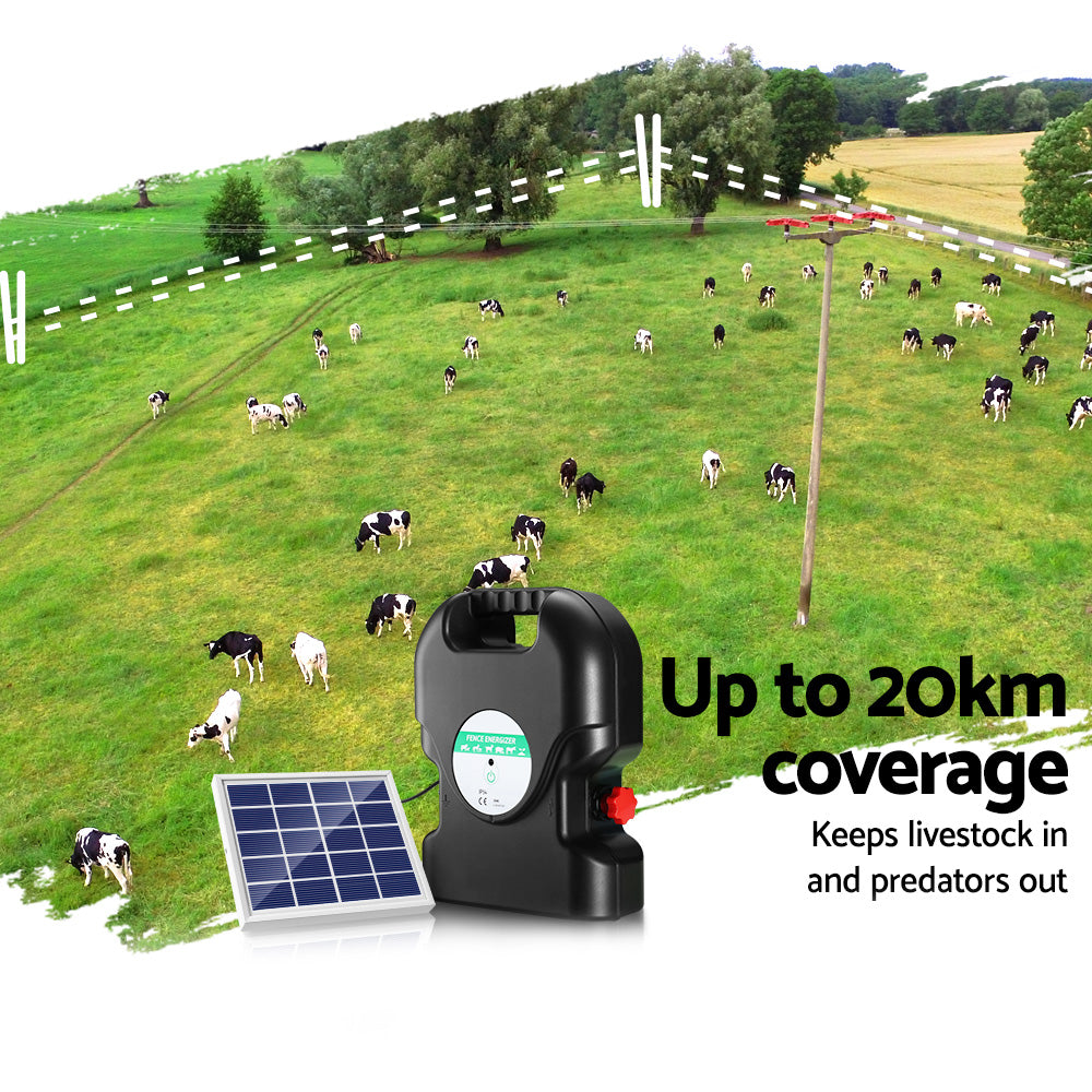 A black, portable Giantz Fence Energiser 20KM Solar Powered 1.2J Electric with a handle on top ensures livestock protection. It's connected to a small solar panel by a cable, employing two red alligator clips attached to black and red wires in front of the waterproof energizer.