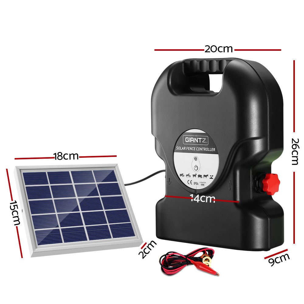 A Giantz Fence Energiser 15KM Solar Powered 0.8J Electric with a handle labeled "GIANTZ" is connected to a small solar panel. Two red and black alligator clip cables are placed beside the controller. The setup is ideal for electric fencing purposes, providing reliable livestock protection.