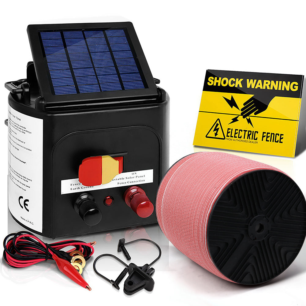 A Giantz Fence Energiser 3KM Solar Powered Electric 2000M Poly Tape is shown alongside a roll of electric fence wire, alligator clips, and a Shock Warning sign. The energiser features a small monocrystalline solar panel on top and various connectors and settings on the front, perfect for effective livestock control.