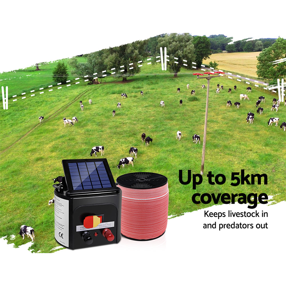 A Giantz Fence Energiser 5KM Solar Powered Electric 2000M Poly Tape is shown, featuring a monocrystalline solar panel, connectors, and a coil of red and black fencing wire. Also included are red and black alligator clips, a black grounding wire with a clip, and a yellow shock warning sign.