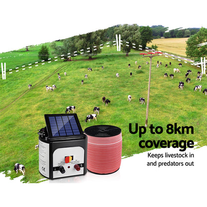 A Giantz Fence Energiser 8KM Solar Powered Electric 2000M Poly Tape kit includes a solar panel unit with control knobs, a roll of electrified wire, a yellow shock warning sign, and various accessories like leads and clips, ensuring reliable livestock protection.