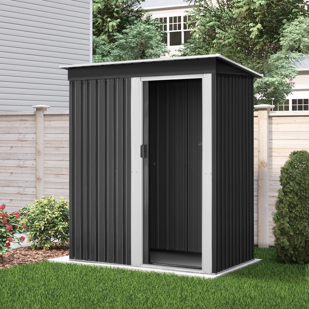 A modern, small black Giantz Garden Shed 1.62x0.86M Sheds Outdoor Storage Tool Workshop House Shelter Sliding Door with a silver-colored door and trim. Constructed from galvanized steel, it features a slanted roof and vertical ridges along the walls and door, designed for weatherproof outdoor storage. The slightly open door offers a glimpse of the interior.