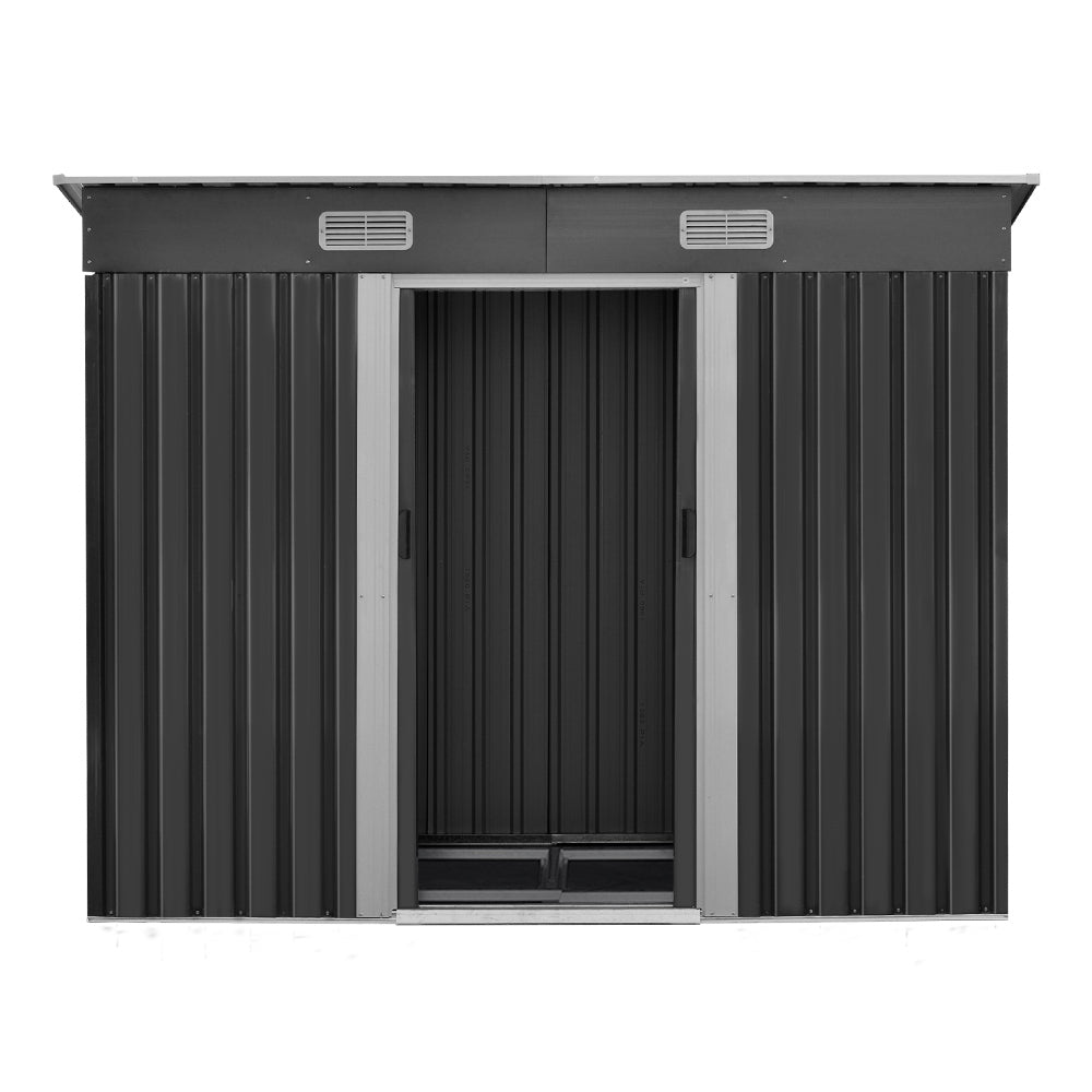 A black metal Giantz Garden Shed 2.38x1.31M w/Metal Base Sheds Outdoor Storage Tool Workshop Sliding Door with open doors reveals an array of garden tools inside. Text on the right reads "Quality construction, Strengthened galvanized steel, Designed for robust use with enhanced durability," along with labels "0.6MM THICK" and "ANTI-RUST" in green circles.