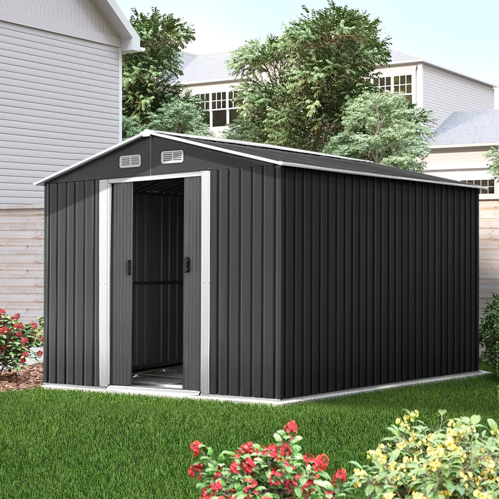 A plain black corrugated metal wall, made from galvanized steel, features a vertical ribbed pattern and a matching flat roof. The Giantz Garden Shed 2.6x3.9M w/Metal Base Sheds Outdoor Storage Workshop Tool Shelter Sliding Door facade is minimalistic and industrial, with no windows or doors visible. The entire weatherproof structure appears boxy and utilitarian, reminiscent of a metal garden shed.