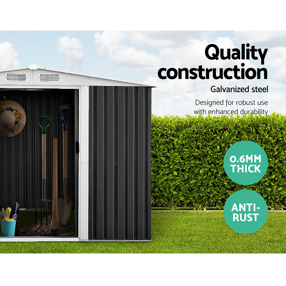 A small garden shed with its door partially open reveals garden tools inside. The text reads "Quality construction, Giantz Garden Shed 2.58x2.07M w/Metal Base Sheds Outdoor Storage Double Door Tool, designed for robust use with enhanced durability." Additional labels indicate "0.6MM Thick," "Anti-Rust," and "Galvanized steel." A green hedge is in the background.