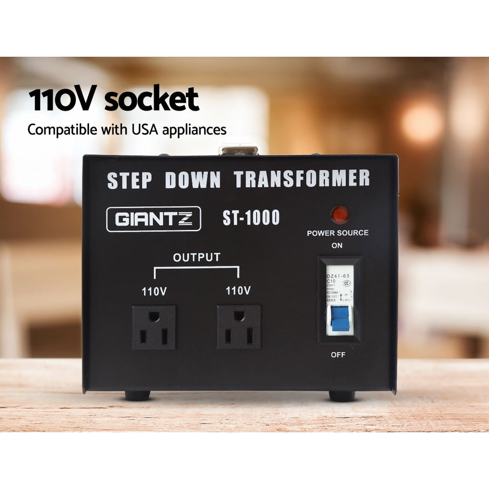 Black step-down transformer labeled "Giantz 1000 Watt Step Down Transformer." It features two 110V output sockets, a power switch, and a red power indicator light. The unit also includes a metal carrying handle on top and ventilation slots on the side. Perfect for those needing a reliable 1000W voltage converter.