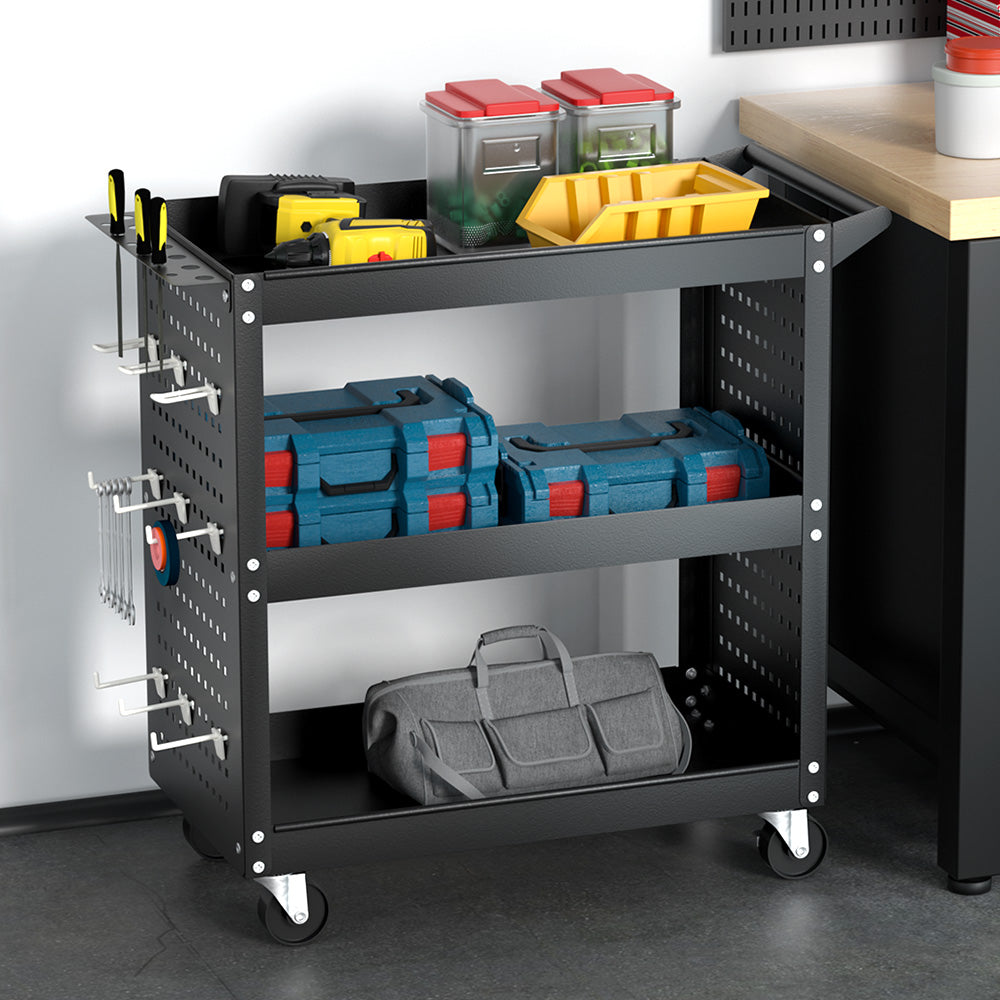 A black metal utility cart with three shelves, mounted on four caster wheels. The Giantz 3-Tier Tool Cart Storage Trolley Workshop Garage Pegboard Hooks Black features a handle at the top for easy movement, and pegboard sides with hooks for its side pegboard tool hanging system and screwdriver storage bay.