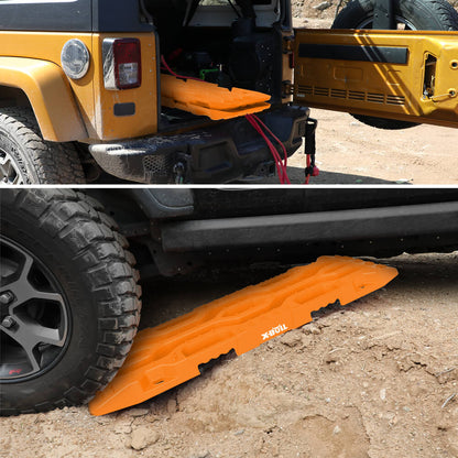 Two bright orange X-BULL 4X4 Recovery tracks Boards Sand tracks Snow Mud 2PCS 12T 4WD Car Truck New are stacked against each other, featuring rugged and textured surfaces for unparalleled grip. They are accompanied by two black straps with silver buckles labeled "RECOVERY." A black and red carrying bag with the "X-BULL 4WD" logo is seen in the background, ideal for off-road use.