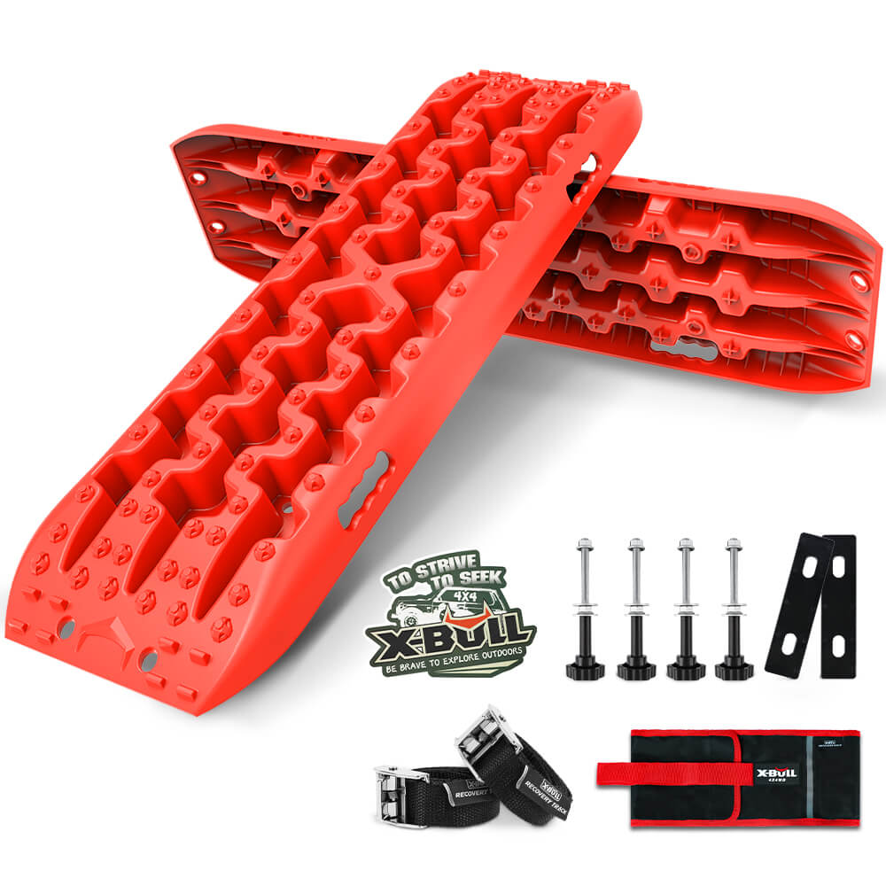 Two red, rugged **X-BULL Recovery tracks Sand tracks KIT Carry bag mounting pin Sand/Snow/Mud 10T 4WD-red Gen3.0** with a U-shape design feature multiple textured grooves and holes, positioned at an angle. Accessories including four bolts, two black straps, black brackets, and a red and black carrying bag with "X-BULL" branding are placed beside the nylon material boards.
