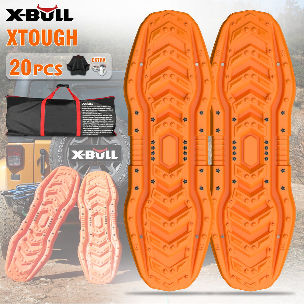 The image showcases two orange X-BULL Recovery Boards tracks kit 4WD Sand Snow trucks Mud Car Vehicles with UV resistance, designed for off-road 4X4 vehicles. Positioned upright against a yellow jeep in a rugged outdoor setting, the text highlights the product name "X-BULL" and mentions an extra 20 pieces of hardware included.