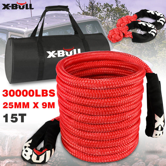 An image showing a red X-BULL Kinetic Rope 25mm x 9m Snatch Strap Recovery Kit Dyneema Tow Winch rated at 30000 lbs, with dimensions of 25mm x 9m (15T). Coiled neatly, the rope has black protective covers on the ends featuring the X-BULL logo. In the background, there's a X-BULL carrying bag and a vehicle in a rugged landscape, ready to harness kinetic energy.