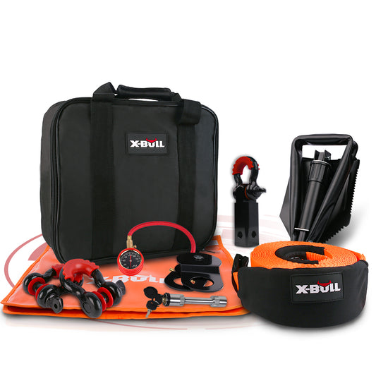 The black Xbull bag with handles holds various recovery gear for off-road vehicles. This comprehensive X-BULL Winch Recovery Kit 11PCS 4WD 4x4 Pack Off Road Snatch Strap Essential includes an orange strap, tire gauge, red shackles, gloves, and a black recovery traction mat. All items are displayed against a white background.