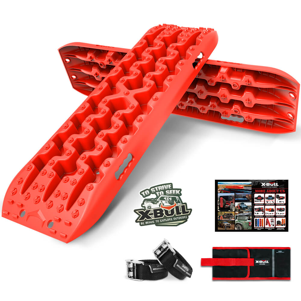 The image shows a set of bright red recovery traction boards branded as "X-BULL Recovery tracks Sand tracks 2pcs 10T Sand / Snow / Mud 4WD Gen 3.0 - Red" in an interlocked position, made from reinforced strong nylon with a 10-ton load capacity. Included are a pair of black straps with metal buckles, an instructional guide featuring images of the product in use, and a red storage bag with a black flap.