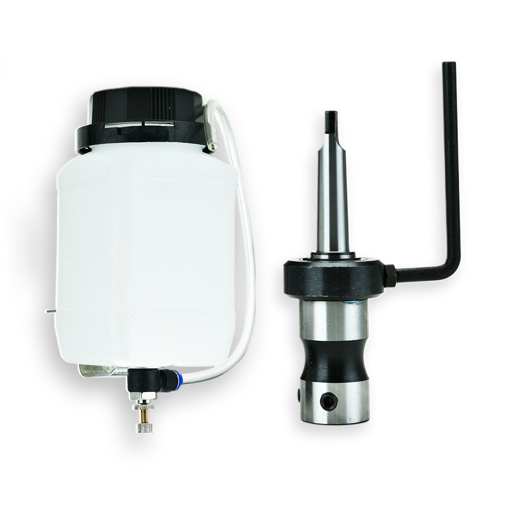 A white plastic container with a black cap is connected to a cylindrical metal tool component with a protruding handle, likely part of a machine tool setup like the Tradie's Mate BAUMR-AG Annular Hole Cutter Converter Kit Morse Taper, placed on a white surface.