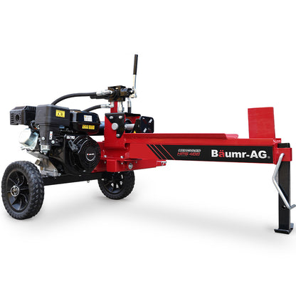 A red Baumr-AG 12 Tonne Petrol Hydraulic Wood Log Splitter - HPS400 is shown. The machine, equipped with a powerful 4-stroke engine, is mounted on two black wheels for mobility, with a control lever and tank. The splitting wedge is positioned at the front end, ready for use.