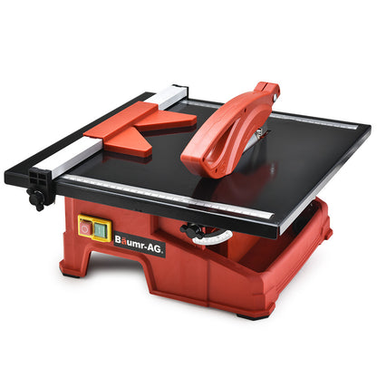 A red and black BAUMR-AG 600W Electric Tile Saw Cutter with 180mm (7") Blade features a wet-cutting system with a powerful 600W motor. The circular blade is partially covered by a protective guard, and the machine sports the "Baumr-AG" logo on the front. It also includes a measurement guide on the top surface for precise cutting.