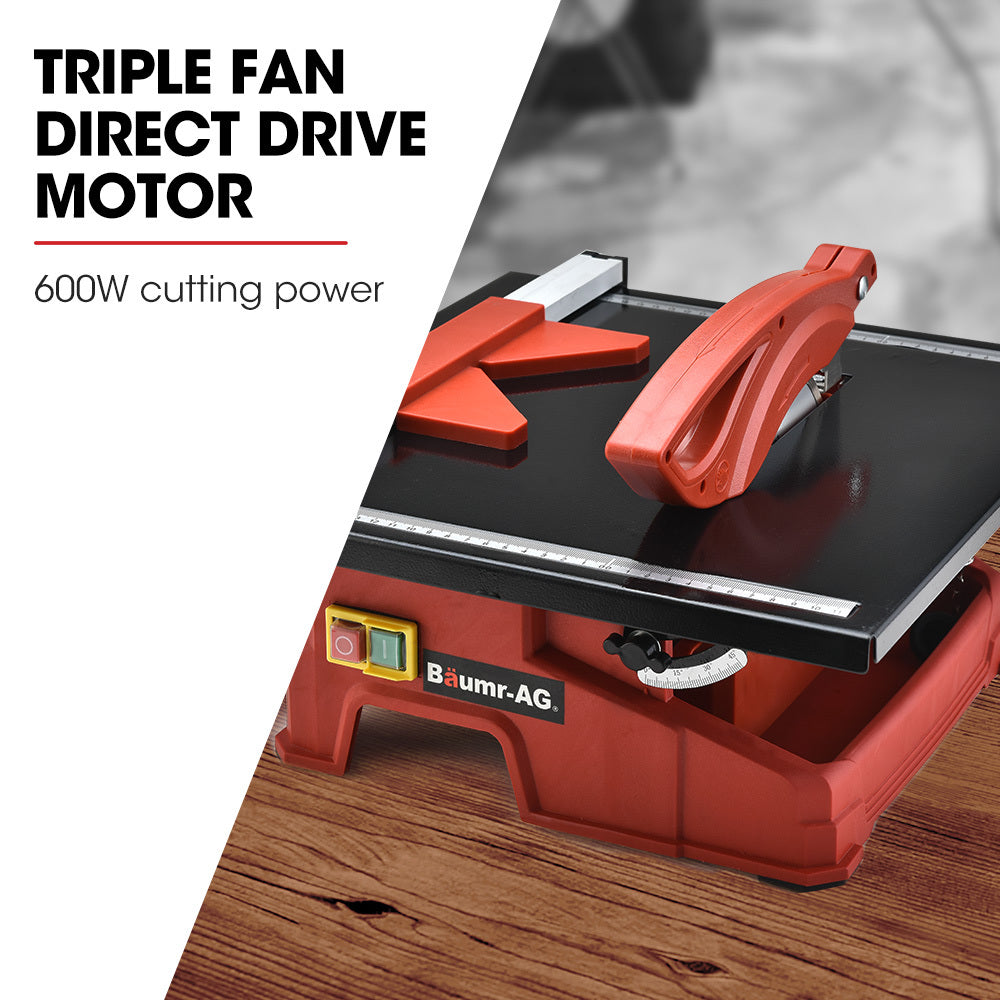 A red and black BAUMR-AG 600W Electric Tile Saw Cutter with 180mm (7") Blade features a wet-cutting system with a powerful 600W motor. The circular blade is partially covered by a protective guard, and the machine sports the "Baumr-AG" logo on the front. It also includes a measurement guide on the top surface for precise cutting.