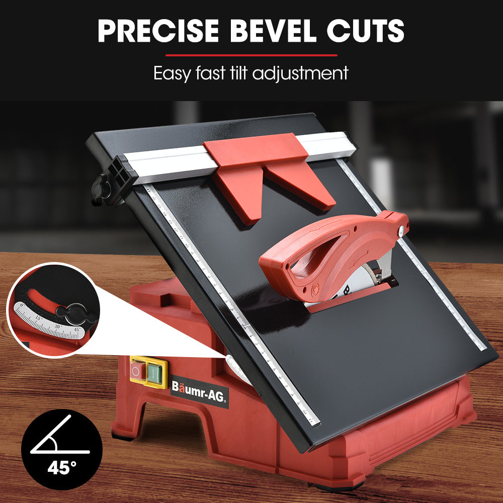 A red and black BAUMR-AG 600W Electric Tile Saw Cutter with 180mm (7") Blade features a wet-cutting system with a powerful 600W motor. The circular blade is partially covered by a protective guard, and the machine sports the "Baumr-AG" logo on the front. It also includes a measurement guide on the top surface for precise cutting.