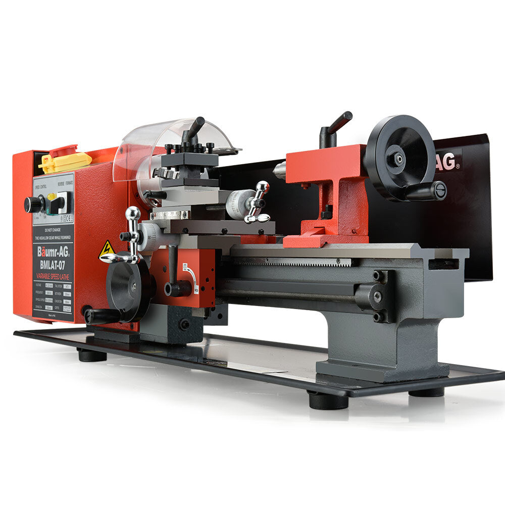 A red and gray BAUMR-AG 600W 7"x14" Variable-Speed Mini Metal Lathe with LCD Screen on a white background, featuring various adjustment knobs, cutting tools, and a transparent safety shield. A label on the machine displays "BMLLAT-07" among other specifications. The lathe is mounted on a black base.