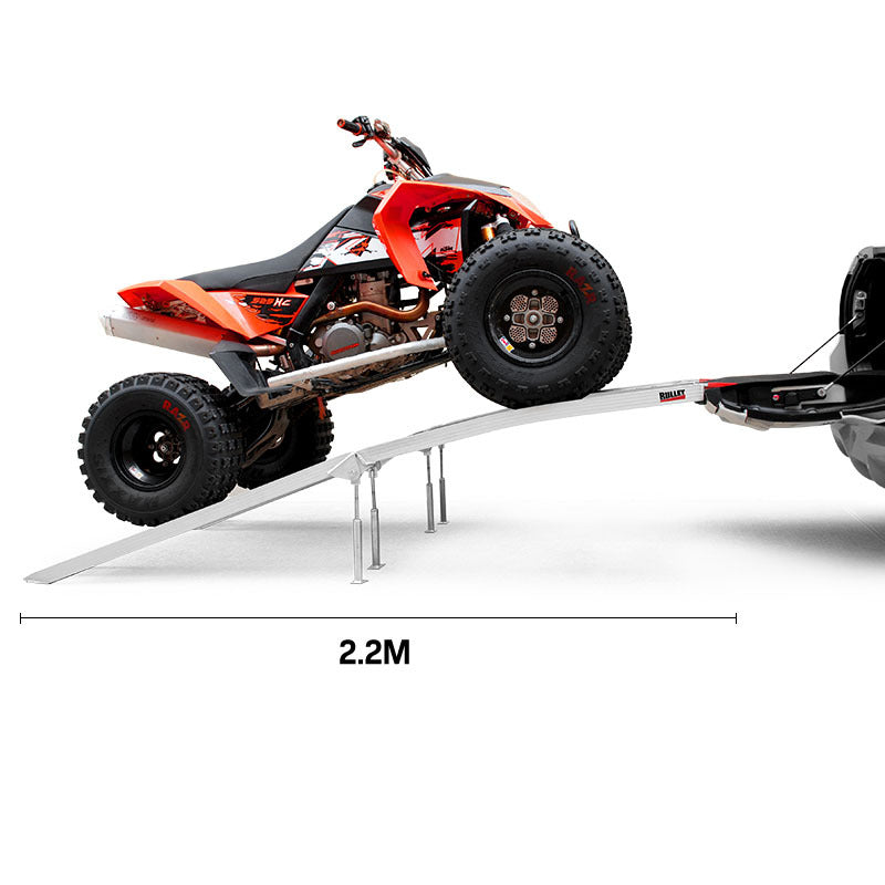 A pair of BULLET Pair of 2.3m Aluminium Loading Ramps, 1360kg capacity crafted from marine grade alloy, featuring perforated surfaces and red-tipped ends. With a 1360kg loading capacity, one ramp lies flat on the ground while the other leans against it in an open position for visibility.