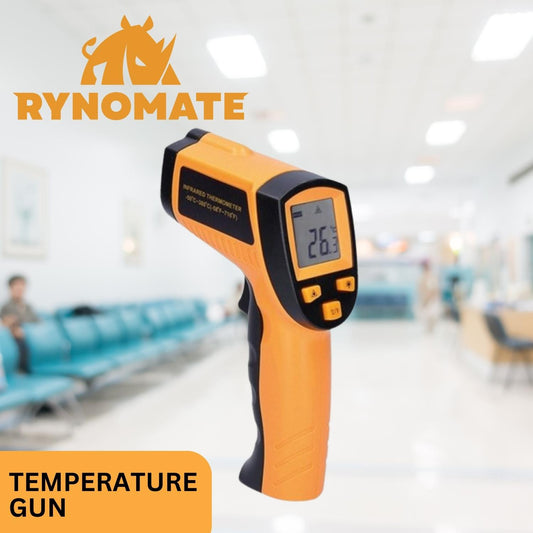 Image of an orange and black RYNOMATE Non-Contact Digital Laser -50℃~550℃ Temperature Gun with Adjustable Emissivity displaying a temperature reading of 26.2°C. The device is branded "RYNOMATE" and is being held in a blurred, sterile-looking room with chairs against the walls. The text "TEMPERATURE GUN" is in the bottom-left corner.