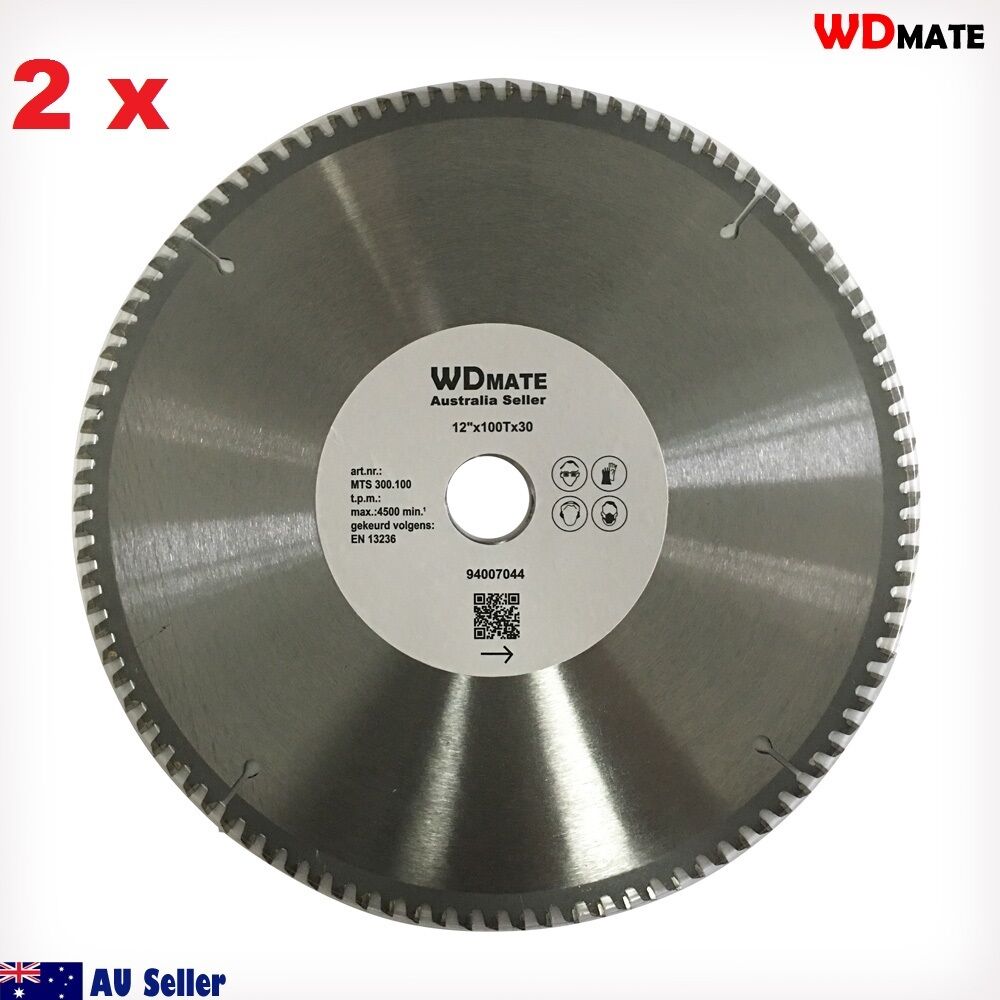 A 2x Cutting Disc 12" 300mm 100T Circular Saw Blade 30/25.4mm Aluminium Plastic with a shiny metal surface and serrated edges. The center has a white label containing text and icons, including the brand "WDMATE" and specifications such as "12’’ x 100T x 1.20." This tungsten carbide tipped blade is ideal for aluminium cutting. The background is plain white.