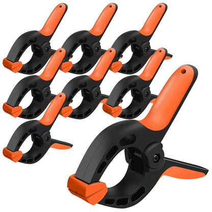 A group of nine HORUSDY 8Pc Spring Clamp Set Quick Grip Plastic Non-Slip Nylon Clips Woodworking are arranged in a staggered pattern. Each clamp, built with heavy-duty nylon construction, features a padded mouth and an ergonomic handle designed for gripping and clamping objects securely, making them ideal for professional woodworking projects.