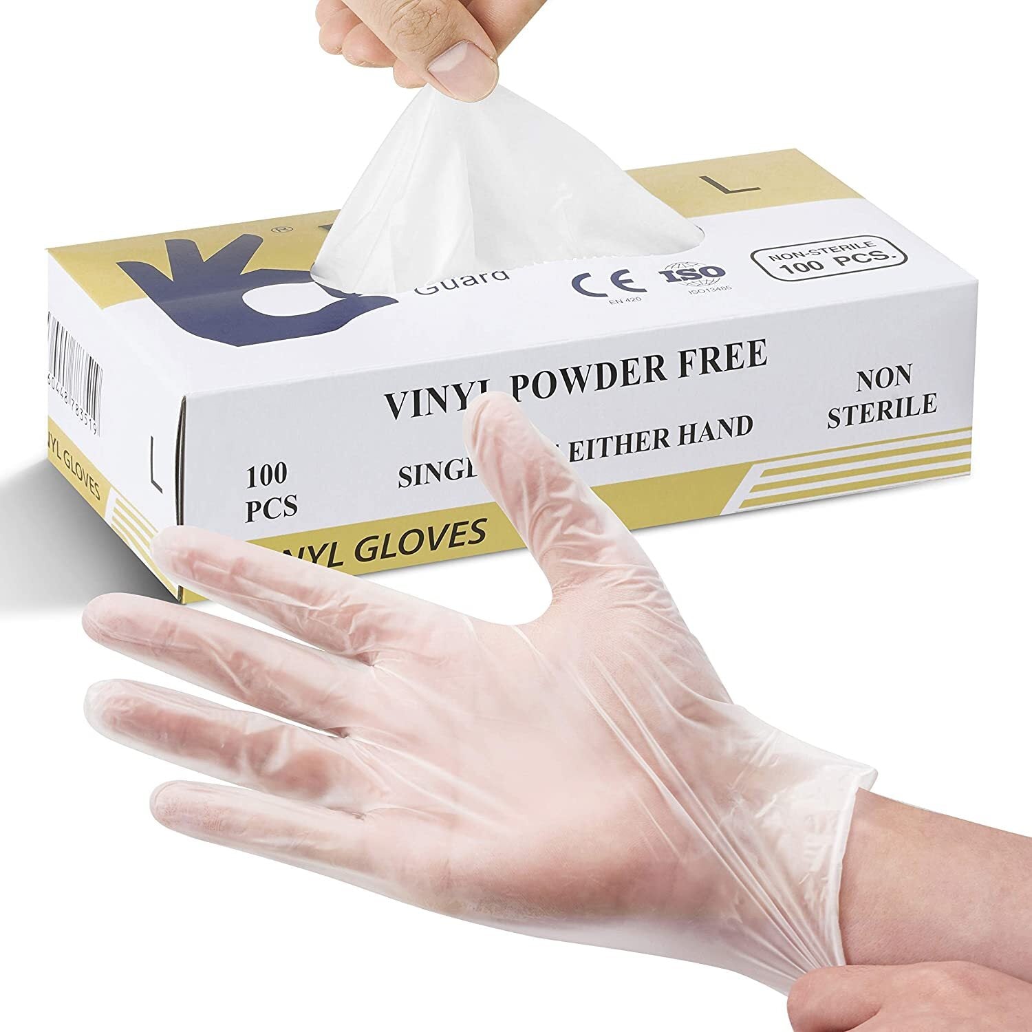 A hand wearing a transparent vinyl glove is shown in the foreground. In the background, a box labeled "100pcs Vinyl Clear Powder Free Disposable Gloves - Medium (1 Box)" is partially opened while another hand pulls out a disposable glove. The box contains 100 non-sterile gloves suitable for either hand.