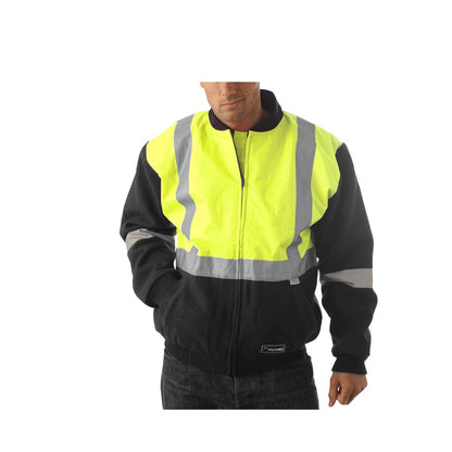 A person wearing a yellow hard hat and a high-visibility jacket with 3M reflective tape stands facing forward. The HUSKI Site Mens Hi Vis Wool Blend Bomber Jacket 3M Reflective Tape High Visibility - Yellow/Navy - 5XL with its yellow and black design also features reflective stripes. Hands in the jacket pockets, the individual looks directly at the camera.